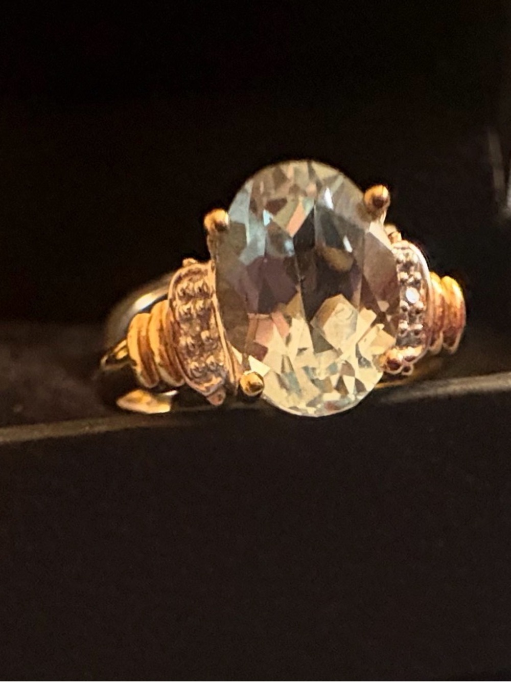 14k yellow gold cocktail ring featuring a large, oval-cut light blue gemstone
